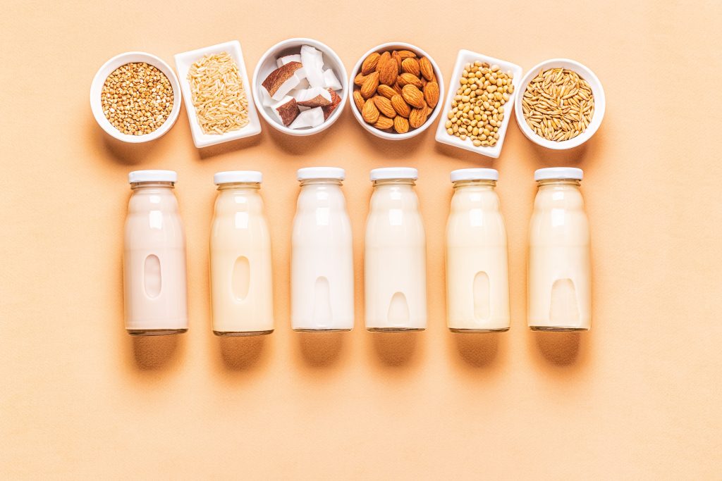 Mehrere Flaschen mit Milchalternativen, wie beispielsweise Mandelmilch, Hafermilch, Kokosmilch